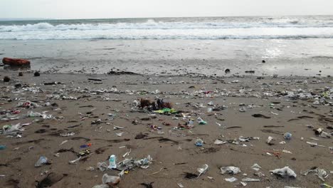 sandy beach full with plastic garbage, polluted nature in bali, indonesia