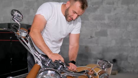 man repairing a motorcycle in a garage