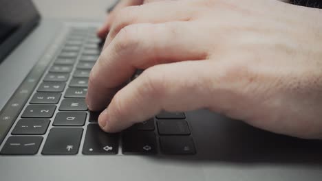 male hands type on a notebook keyboard