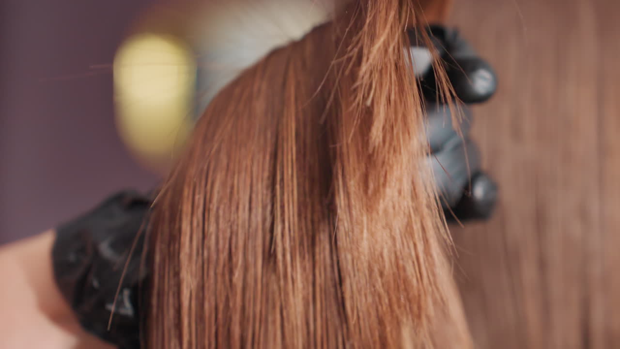 Escena de precisión en un corte de pelo: un estilista recorta los detalles de una peluca de forma profesional. Un estilista caucásico perfila cuidadosamente las puntas del cabello en un salón tranquilo mientras el peluquero esculpe y recorta meticulosamente los mechones.
