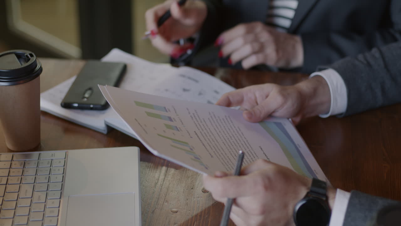 Business People Reviewing Documents in a Cafe
