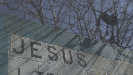 Cinderblock-wall-with-Jesus-written-on-it