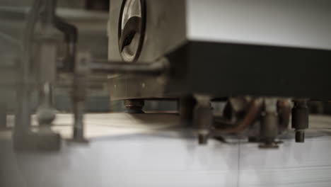 close up of the printing machine where machine is separating and lifting sheets of paper and sending it forwad on the production line