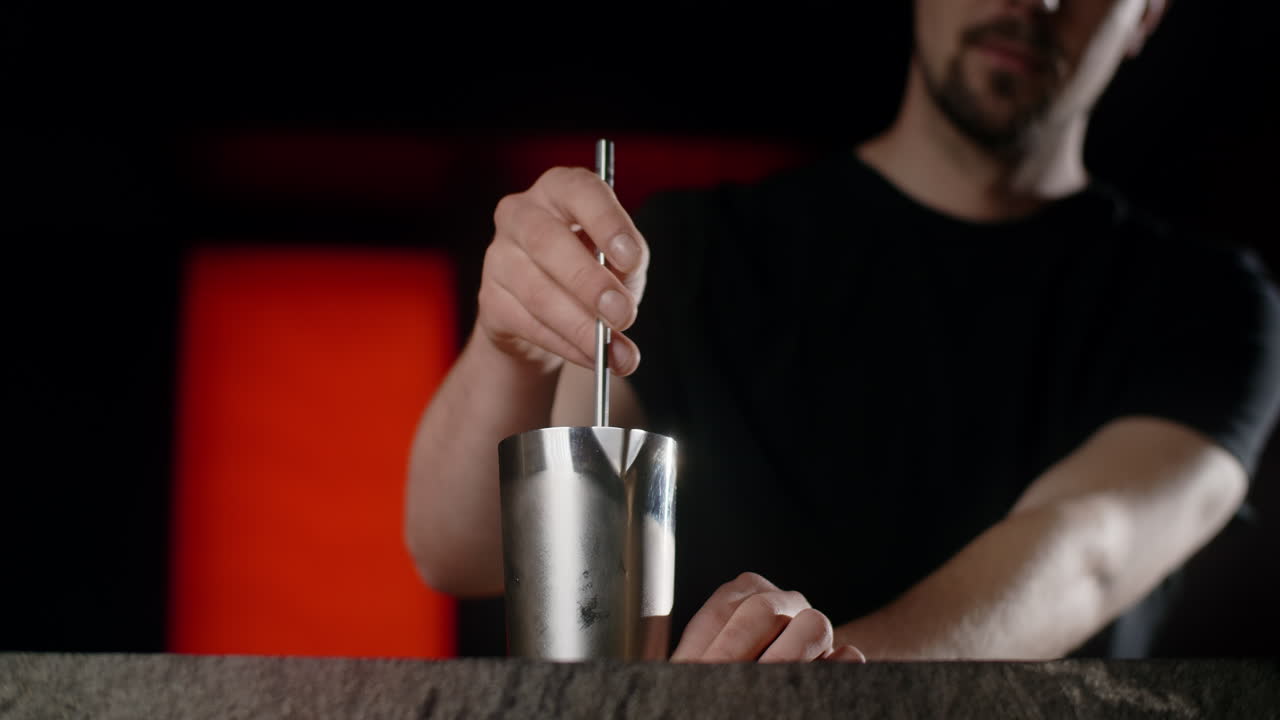 el camarero mezclando un cóctel.