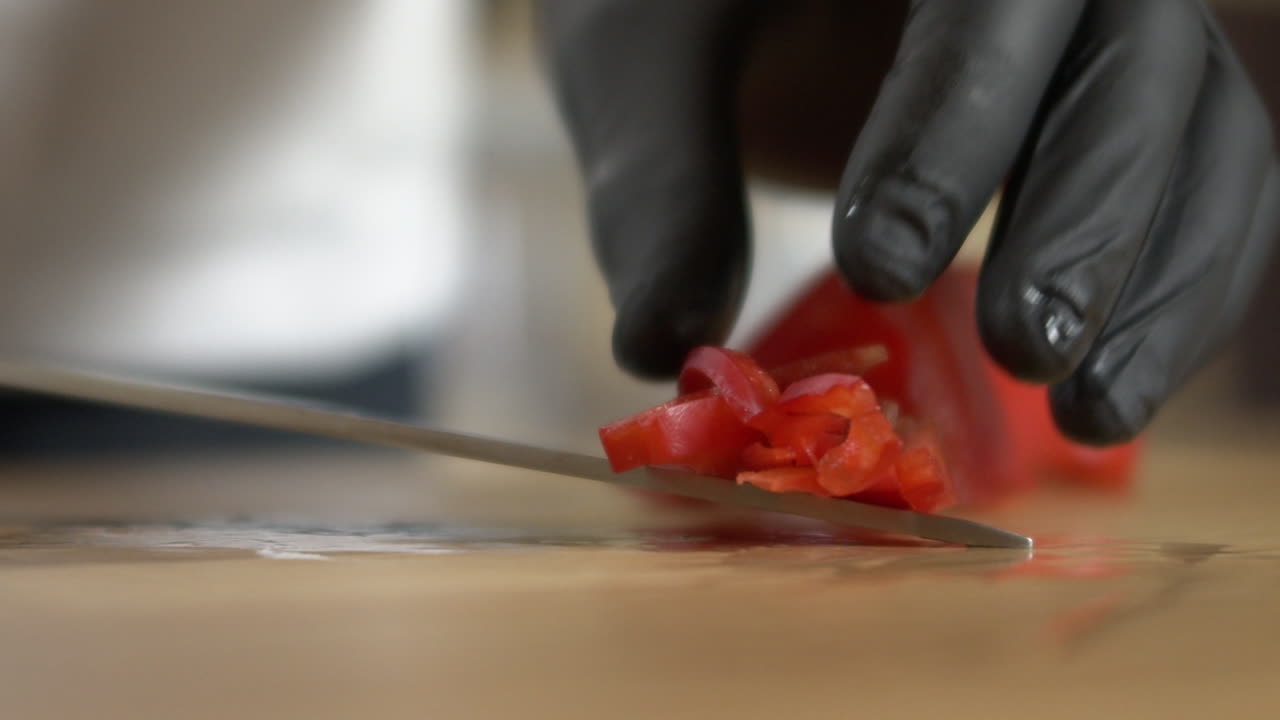 chef recoge un pimiento rojo en rodajas con un cuchillo, apple prores slow-mo