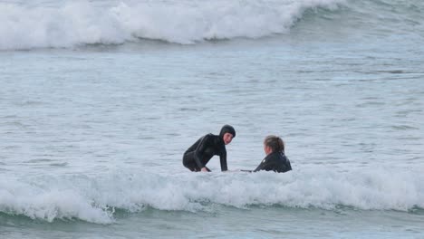 two surfers practicing in ocean waves