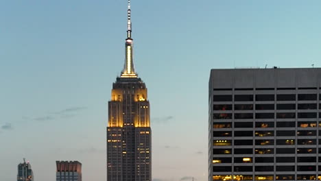 aerial view behind a mirroring skyscraper, revealing the empire state building in ny