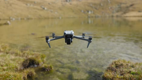 drone hovering above edge of lake in italian alps