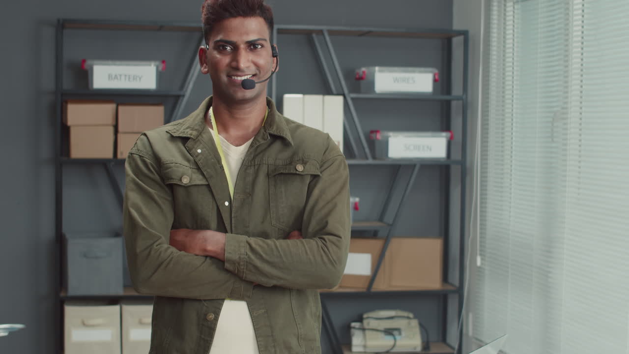 Manager Wearing Headset Smiling at Camera at Electronics Repair Center