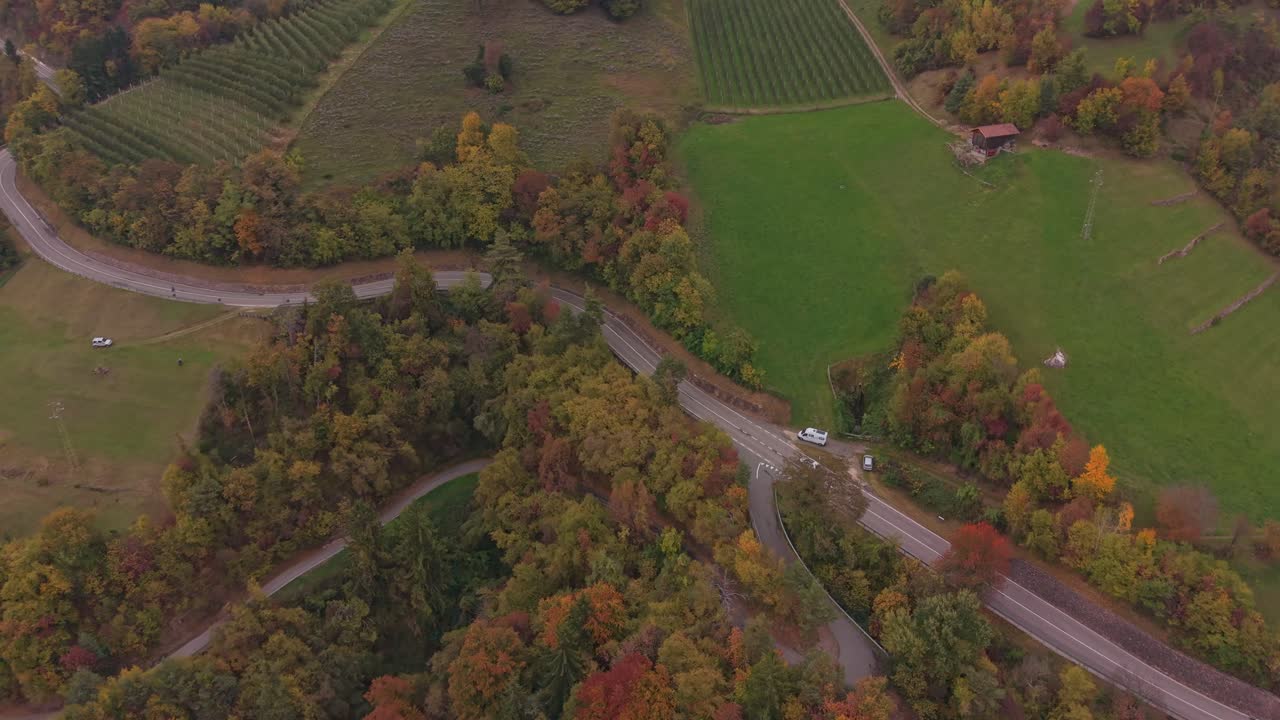Efterårs-droneudsigt af bil, der kører på naturskøn bjergvej i Sydtyrol, Italien