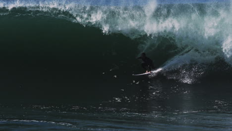 tight tube forms dramatic funnel over rider who disappears into dark barrel