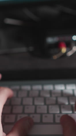 primer plano de los dedos masculinos escribiendo en un teclado de computadora, que representa el trabajo y el uso de la tecnología
