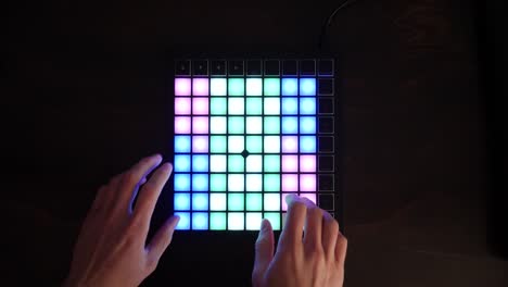 un productor de música electrónica que usa un instrumento midi digital en un estudio con luces led