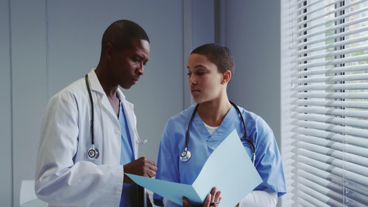 vista frontal de los médicos africanos discutiendo sobre el archivo médico en el hospital 4k