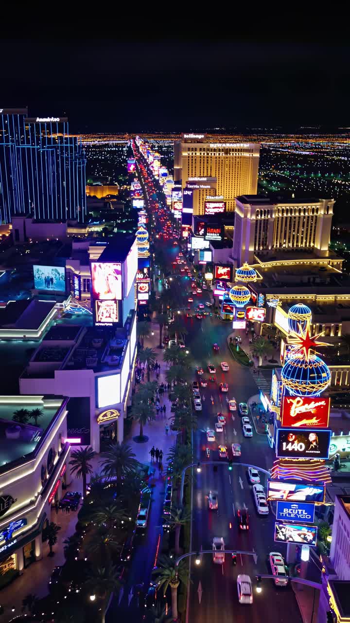 Aerial view of a vibrant city street at night, illuminated by neon lights