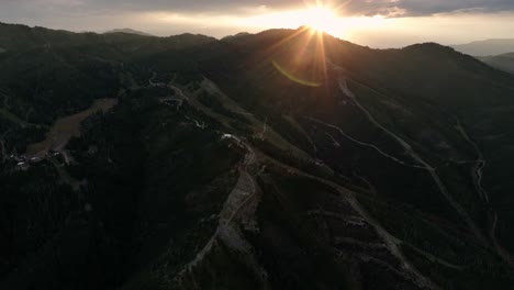 La-Panorámica-Aérea-Revela-La-Puesta-De-Sol-Sobre-Las-Pistas-De-Esquí-En-La-Montaña,-Con-Una-Hermosa-Formación-De-Nubes-En-El-Cielo