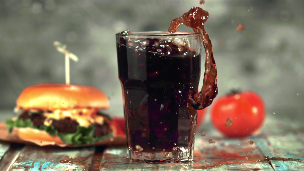 Ice Cube Dropping into a Glass of Cola with a Splash