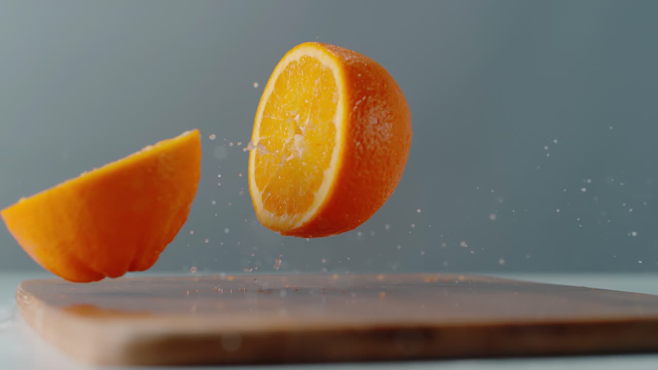 Laranja Cai e se Parte na Tábua de Corte com um Jato de Suco.