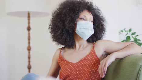 woman wearing face mask sitting on the couch at home