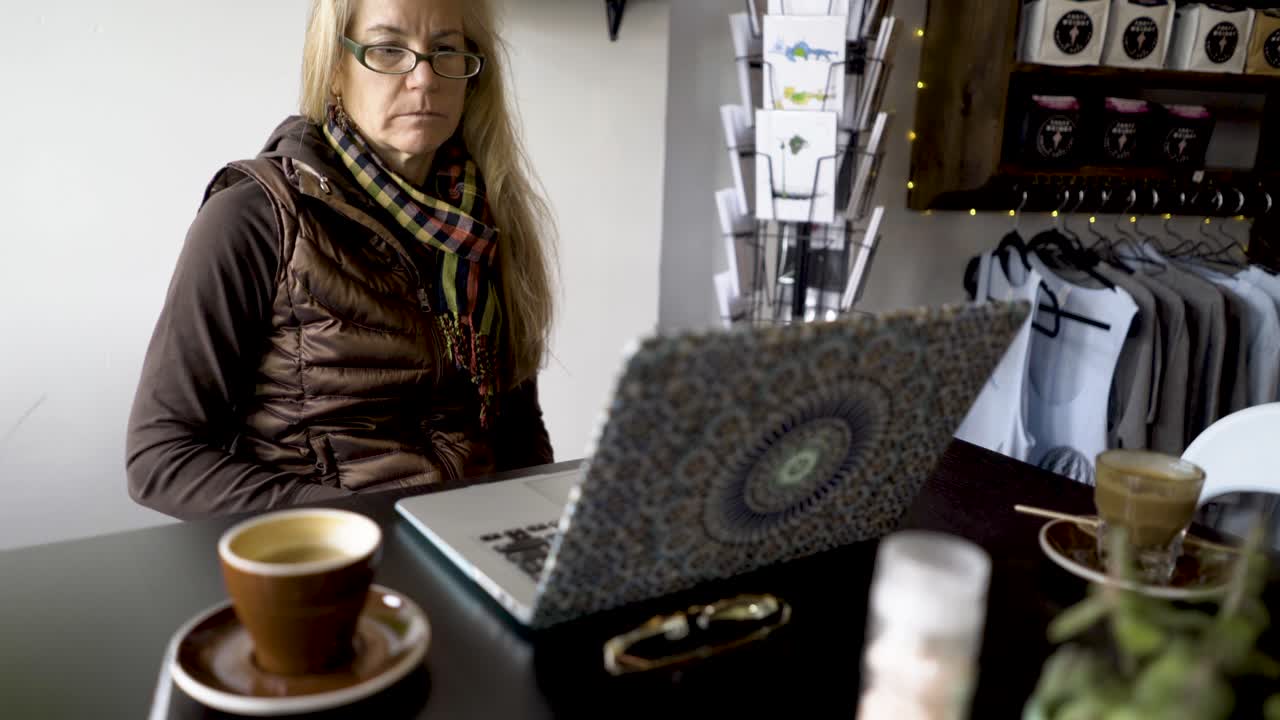 mujer trabajando en una computadora portátil en un café