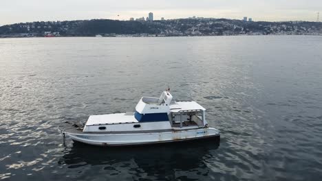 slow aerial over a lone boat bobbing in the bosphorus strait