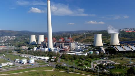 Planta-De-Energía-Térmica-Con-Chimenea-Humeante-Al-Lado-Del-Pueblo-En-Una-Tarde-Luminosa-Y-Soleada