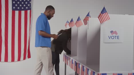 man walking into booth with ballot paper to cast vote in american election in slow motion 1