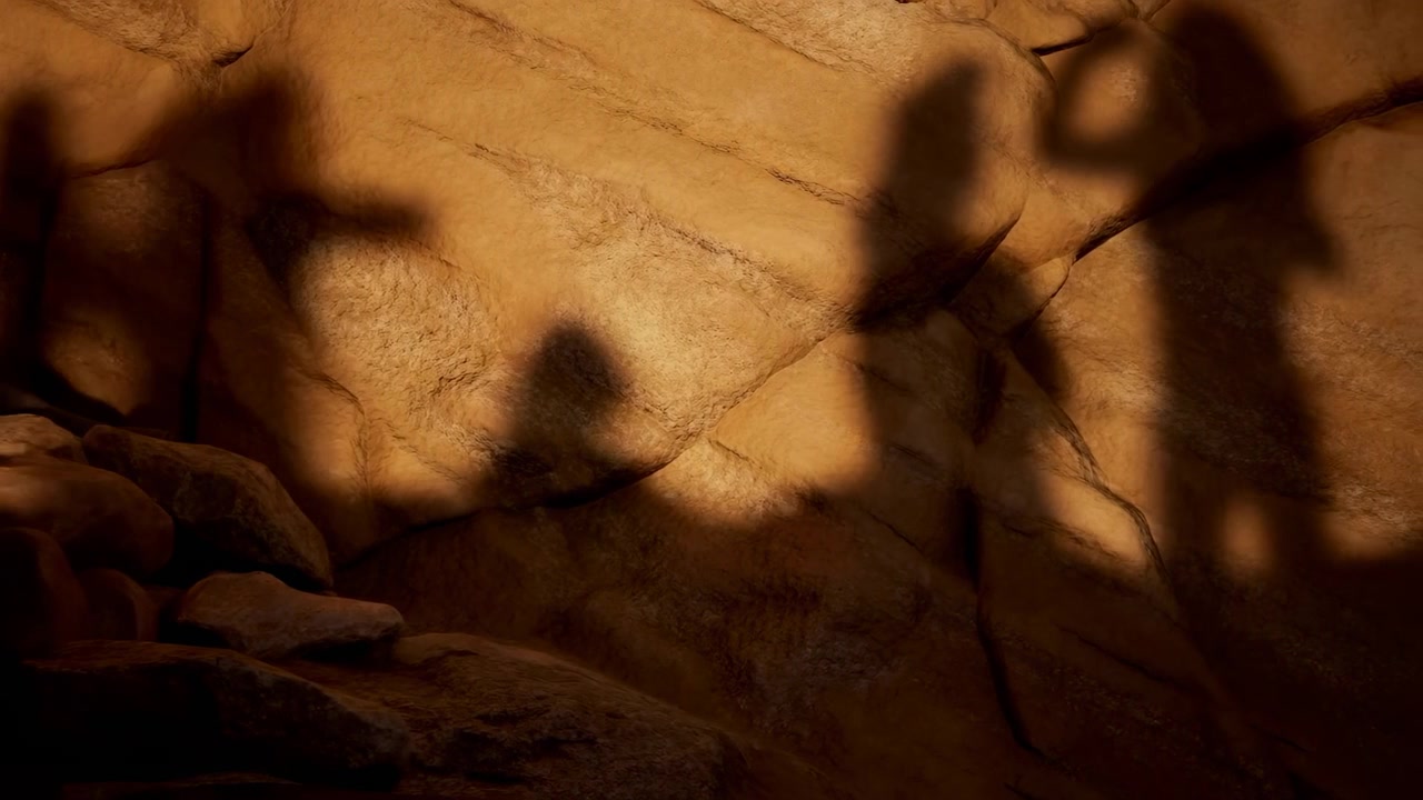 Soft human silhouettes change position and extend their arms across golden brown rock, while warm illumination reveals coarse surfaces, deep crevices, and layered stones in foreground.