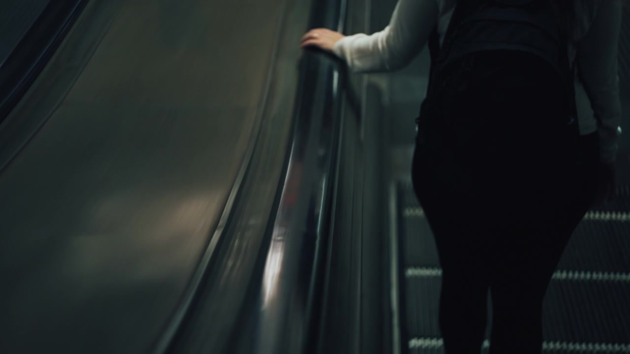 Wanita turun dari eskalator