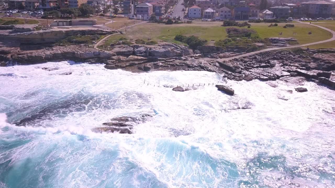 Strong blue waves in ocean crashing on the shore