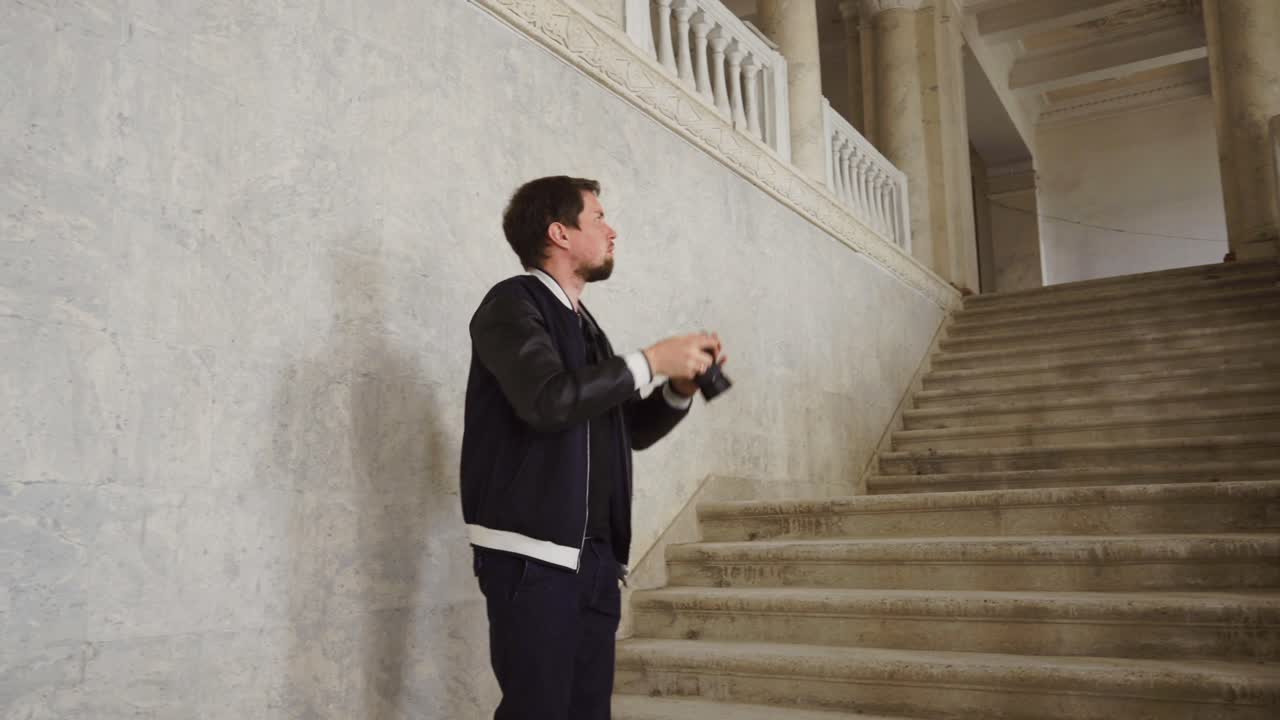 мужчина фотографируется на лестнице старого здания.