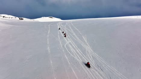 aerial view of people riding snowmobiles on the icy ground of myrdalsjokull glacier in iceland