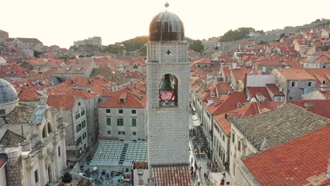 Toma-Aérea-Del-Campanario-Y-La-Calle-Peatonal-Del-Casco-Antiguo-De-Dubrovnik,-Croacia