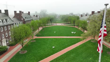 Aerial-drone-videography-of-American-flag-flying-above-college-campus