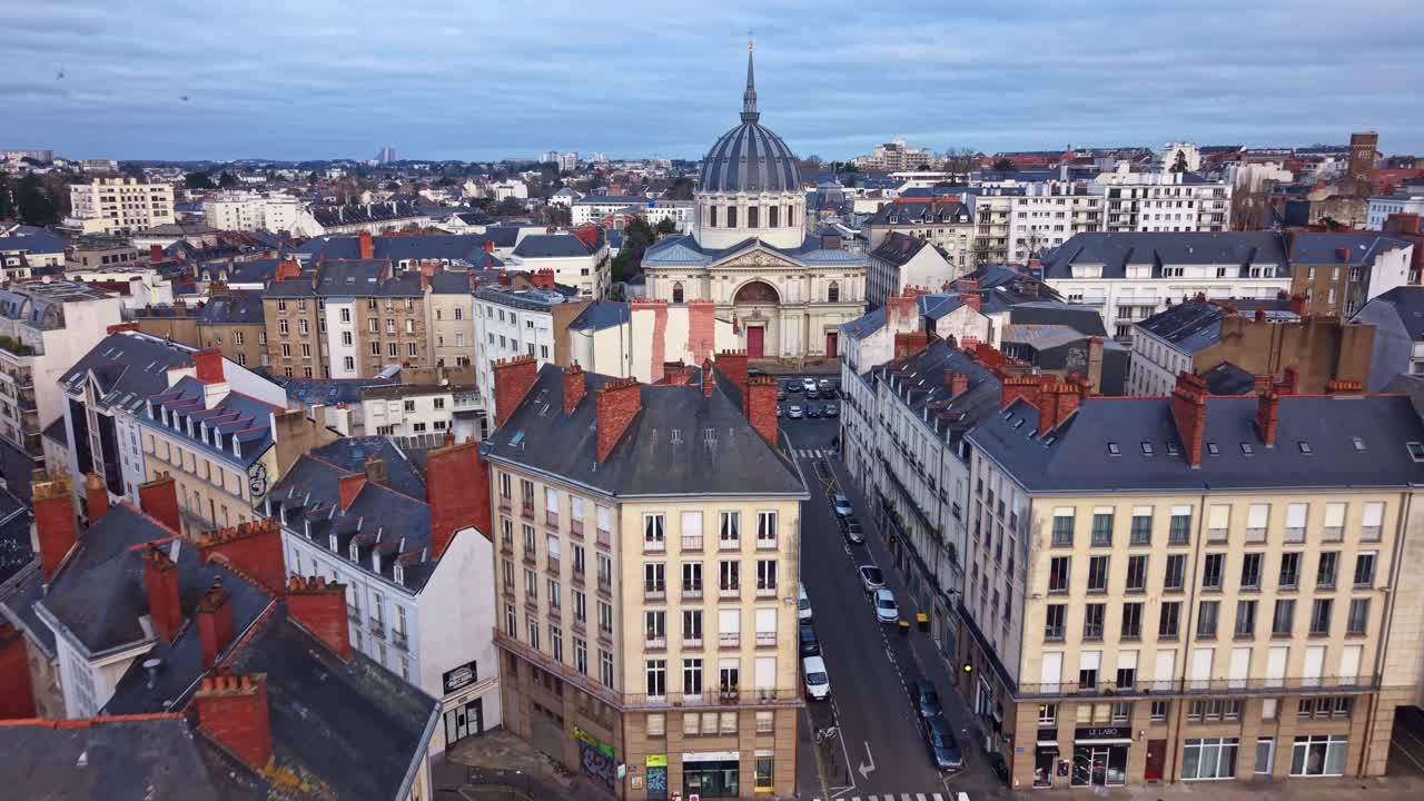 Église Notre-Dame-de-Bon-Port in Nantes. The beautiful church dome stands out against the city's rooftops. Ideal for French travel and religious architecture, France. Aerial drone forward