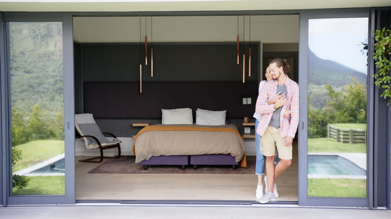 un giovane uomo caucasico si trova vicino alla porta del patio aperta, copia lo spazio