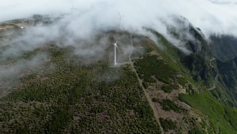 Vuelo-De-Drones-Sobre-Una-Niebla-épica-Rodando-Sobre-Una-Turbina-Eólica-Giratoria-En-La-Montaña-De-Madeira