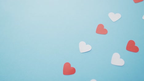 Multiple-red-and-pink-paper-hearts-at-valentine's-day-on-blue-background