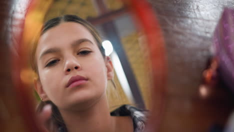 el reflejo en el espejo de una hermosa chica se asegura cuidadosamente de que el maquillaje esté bien aplicado, el primer plano destaca la rutina de belleza, el cuidado personal y el cuidado facial en un entorno suavemente iluminado