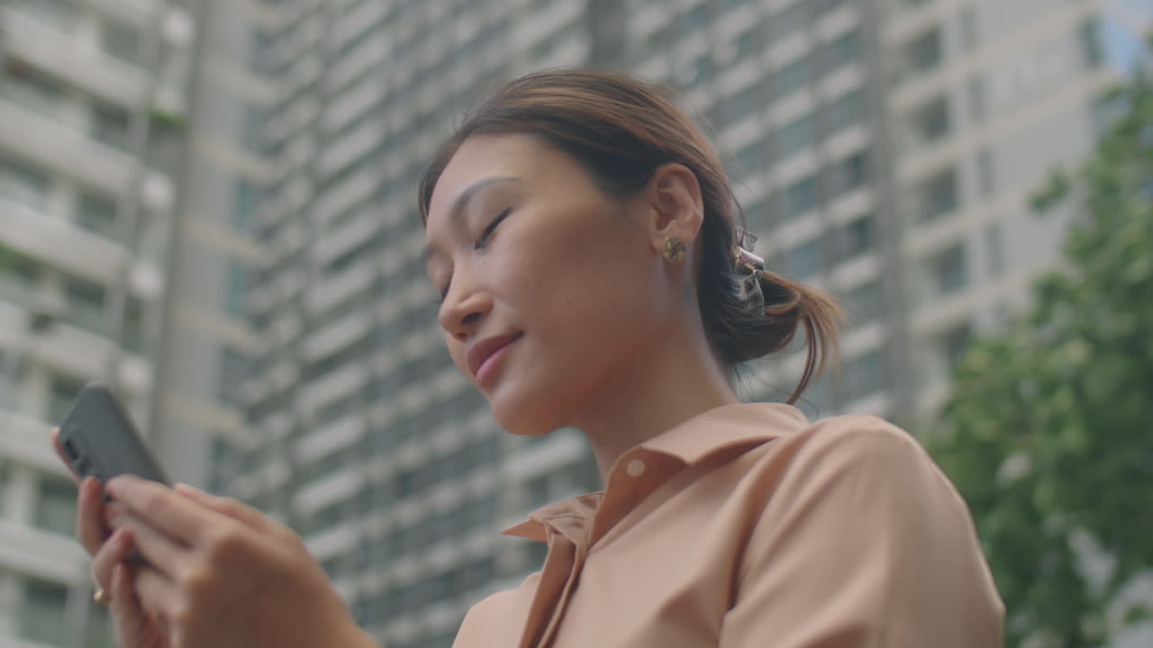 Asian Business Lady Using Smartphone on Street