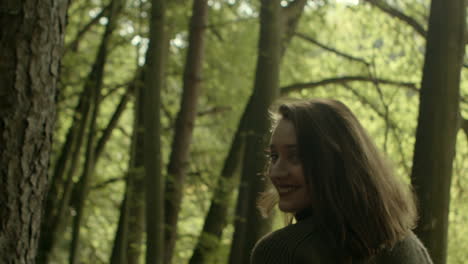 smiling beautiful walking woman enjoys autumn forest