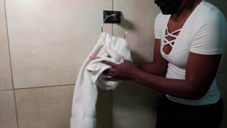 african lady drying hands during covid-19 on towel