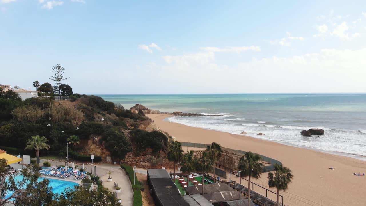 lujosas vistas al mar sobre el hotel junto a la playa y la costa mediterránea en albufeira, algarve, portugal - revelar toma aérea
