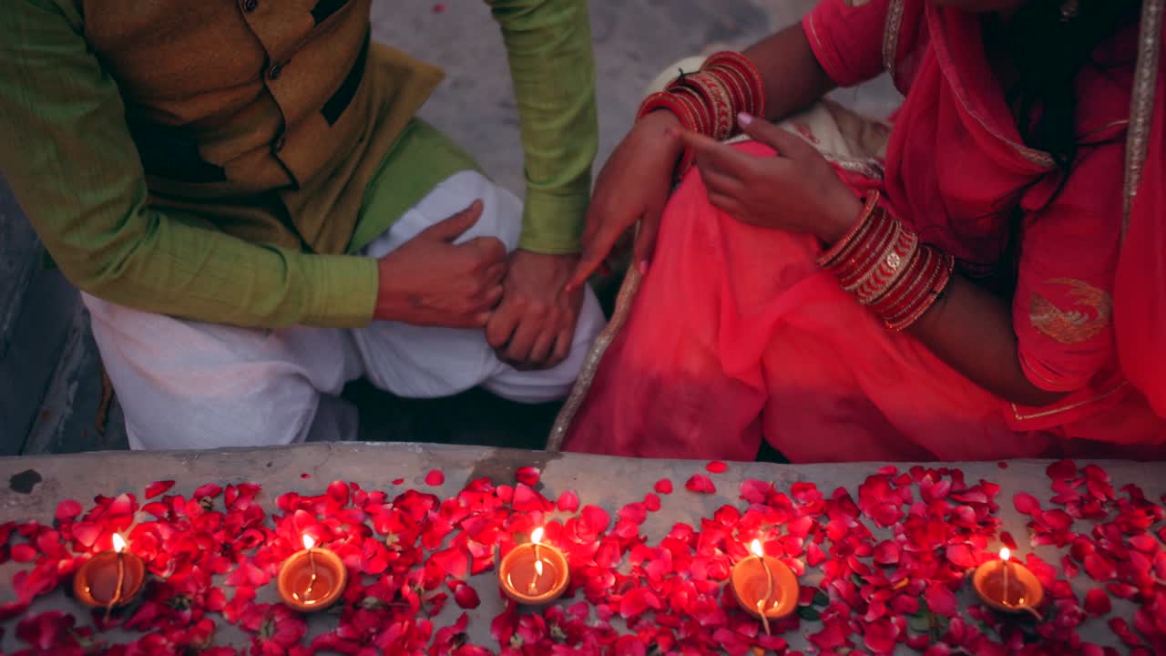 Par fejrer en farverig Diwali rangoli - rød, pink, orange, grøn