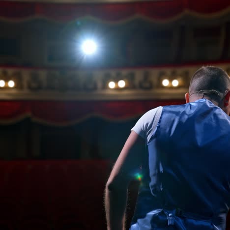 middle age male entertainer, presenter or actor on stage. public speaker gives performance in front of empty auditorium. man in theater
