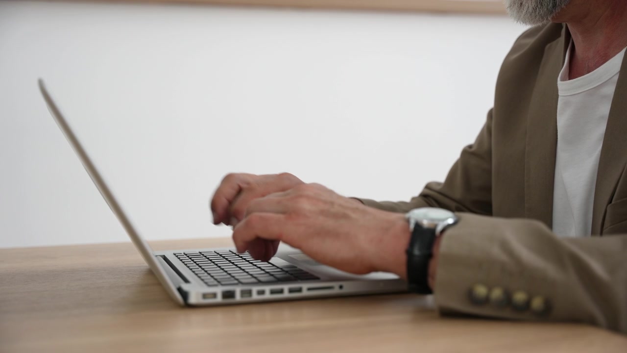 Uomo maturo che digita su un laptop alla scrivania