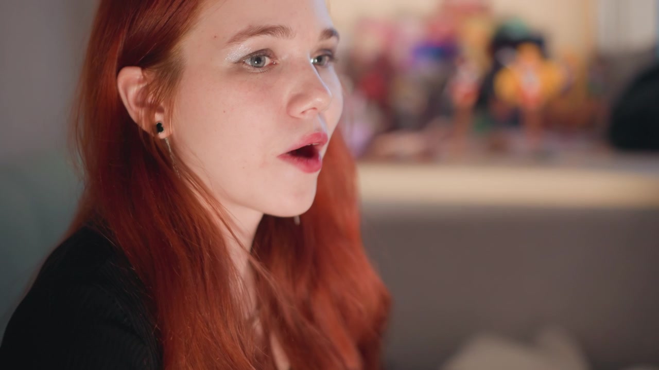Figura feminina pensativa em ambiente íntimo. Mulher pensativa com brilho quente e reflexão privada. Mulher ruiva serena parece imersa em pensamentos em meio a um ambiente suave de luz de velas e solidão