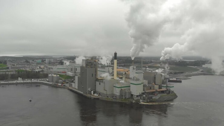 Aerial shot of the Irving Pulp and Paper factory shooting toxic smoke into the air on a cloudy day near the reversing falls.