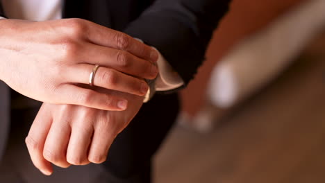 The-groom-wearing-his-watch-in-his-hand-on-the-wedding-day---close-up