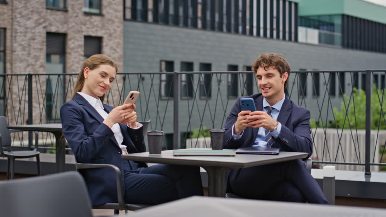 Businessman businesswoman relaxing at street cafeteria. Smiling colleagues